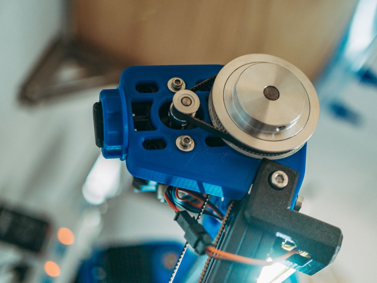 A handheld 3D scanner capturing the geometry of a metal mechanical part.